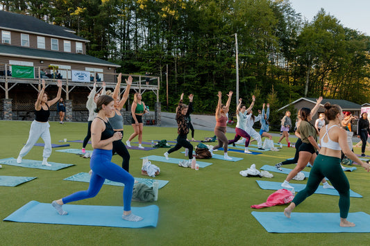 Outdoor yoga class at a wellness retreat by Camp Social