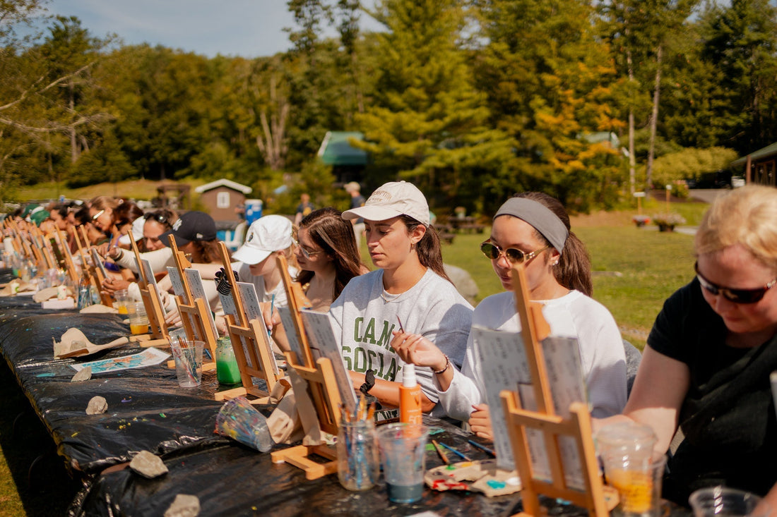 Women painting outdoors at a summer camp activity