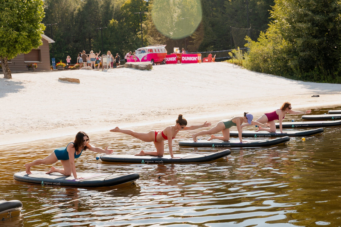 Women enjoying paddleboard yoga on the lake at Camp Social