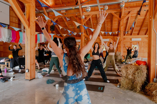Group yoga session inside a wooden lodge by Camp Social