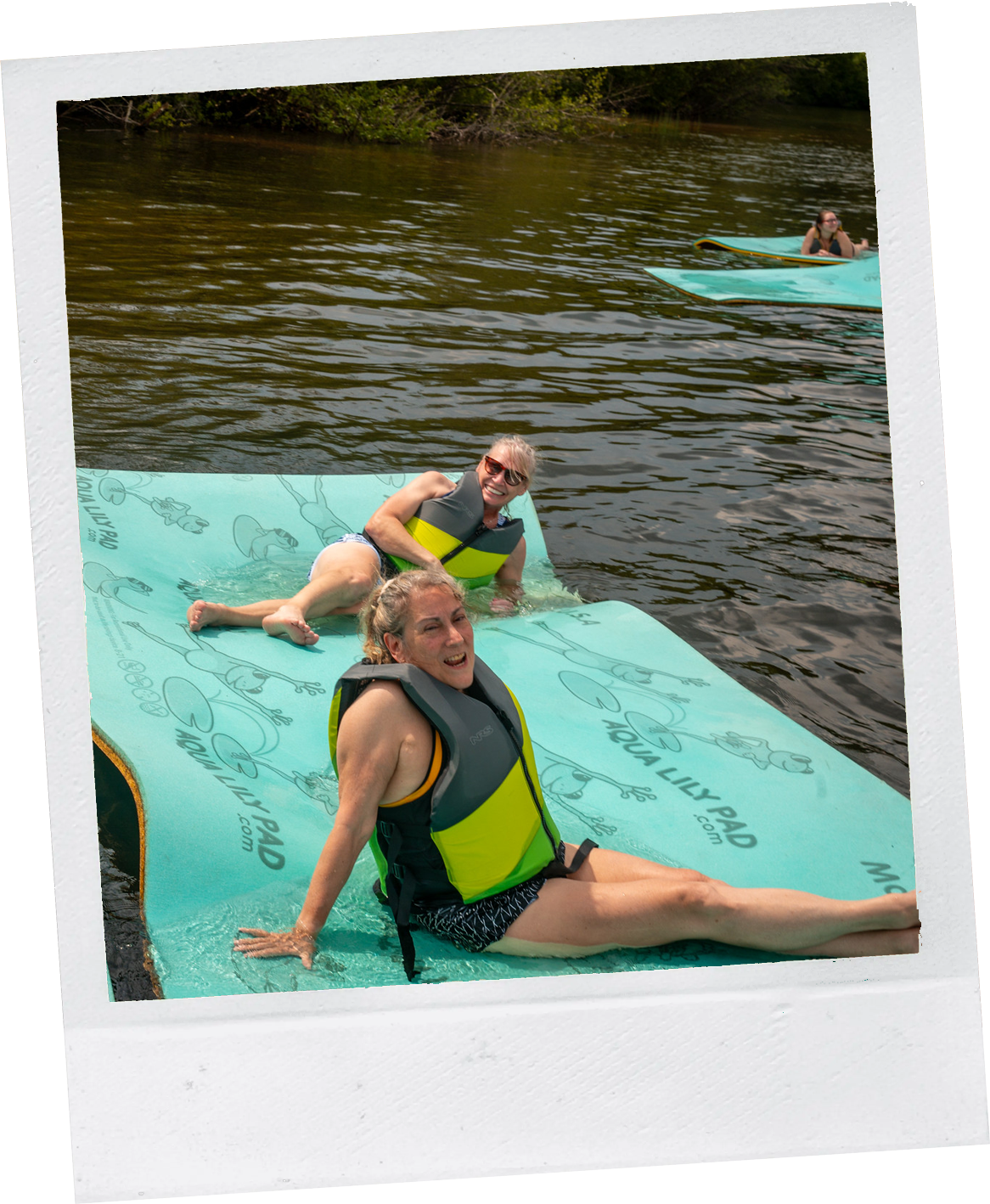 women on floatation mats at camp social